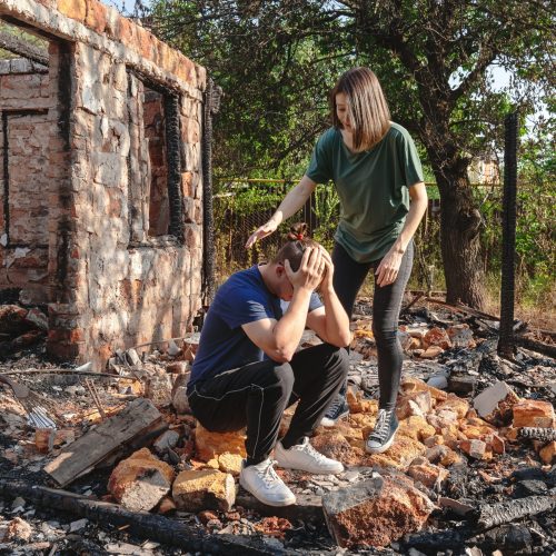 A devastated young couple after their home was destroyed by fire
